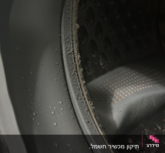 תוף מכונת כביסה עם טיפות מים על הגומי